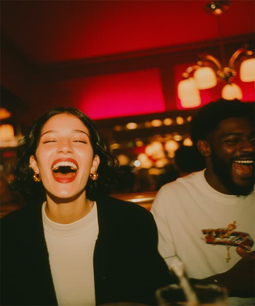 Friends laughing together in a red-lit restaurant